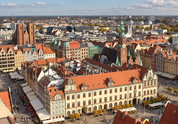 Ilustracja AI oparta na panoramie Rynku Wrocławia i Ratusza z wieży bazyliki św. Elżbiety.