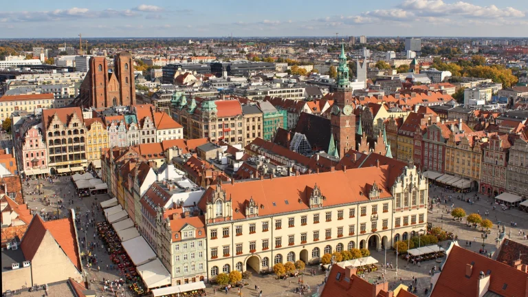 Ilustracja AI oparta na panoramie Rynku Wrocławia i Ratusza z wieży bazyliki św. Elżbiety.